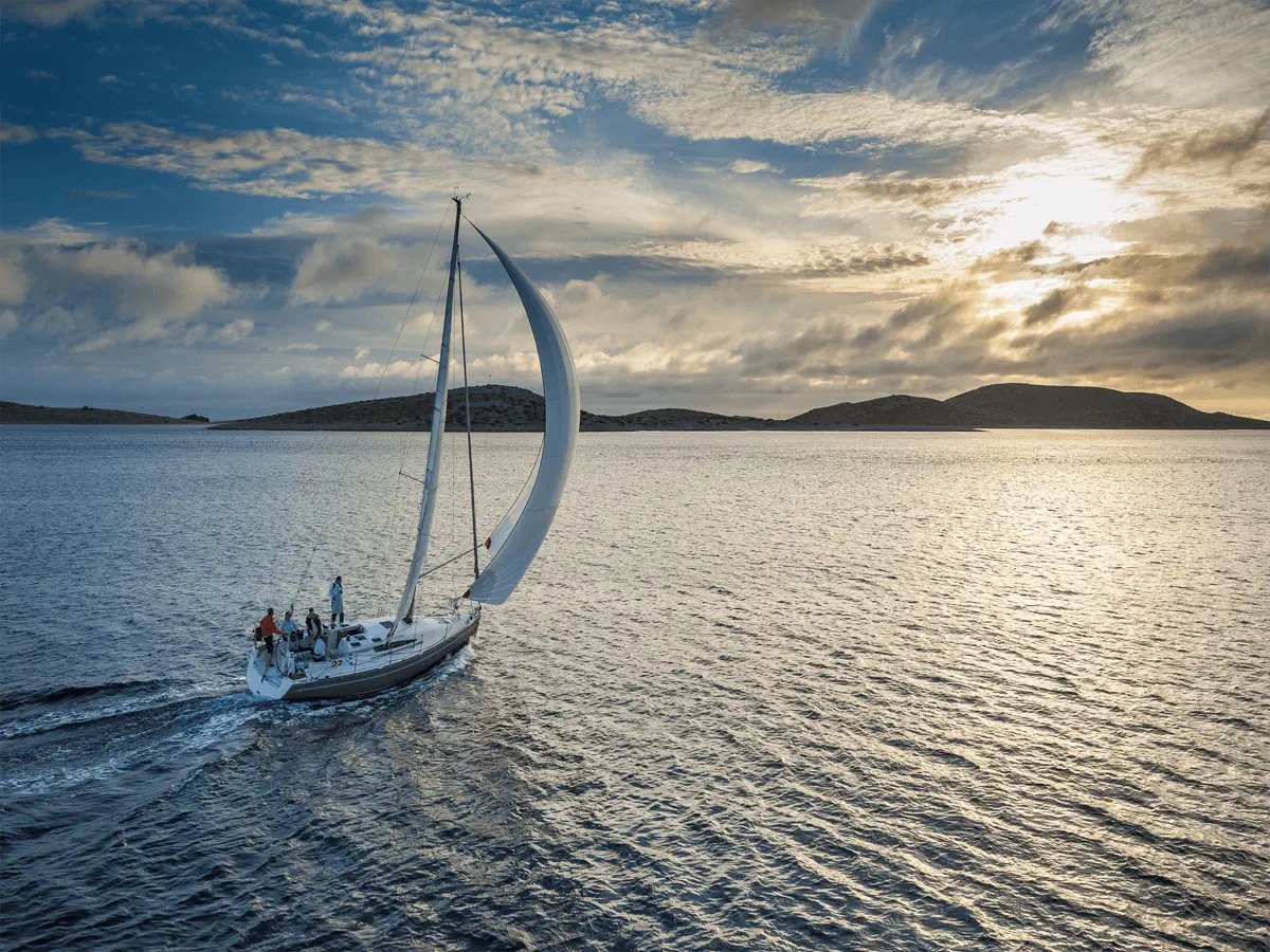 sailboat on open water sailing into the sunset